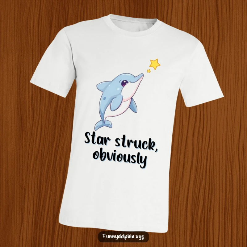 Funny Dolphin T-Shirt: A cute dolphin with a curious head tilt observes a floating star, perfect for quirky space lovers.