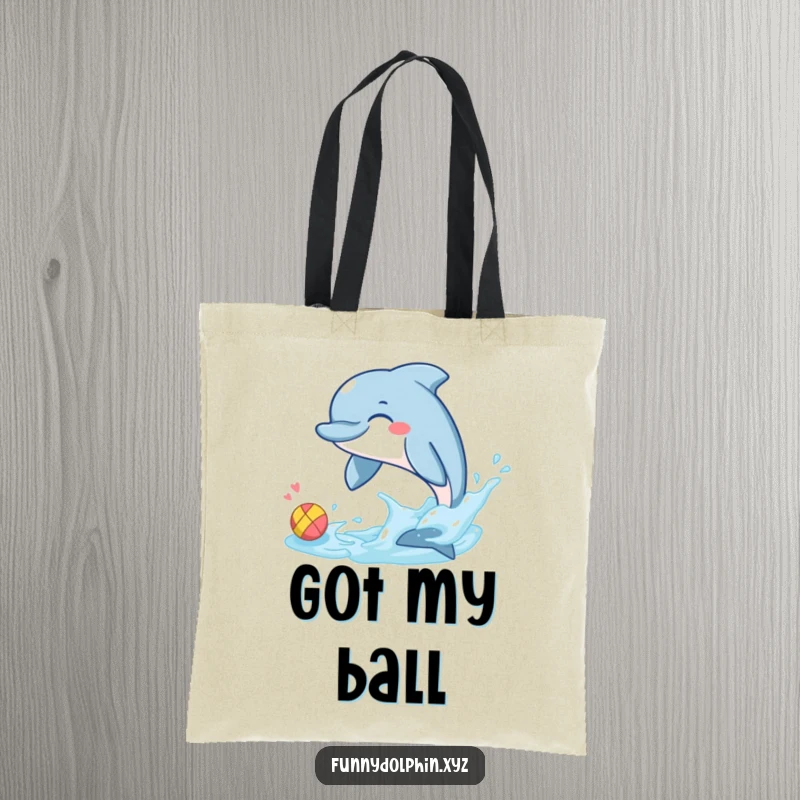 Funny tote bag depicting a giggling dolphin using its tail fin to splash a tiny, colorful ball. Great for beach days!